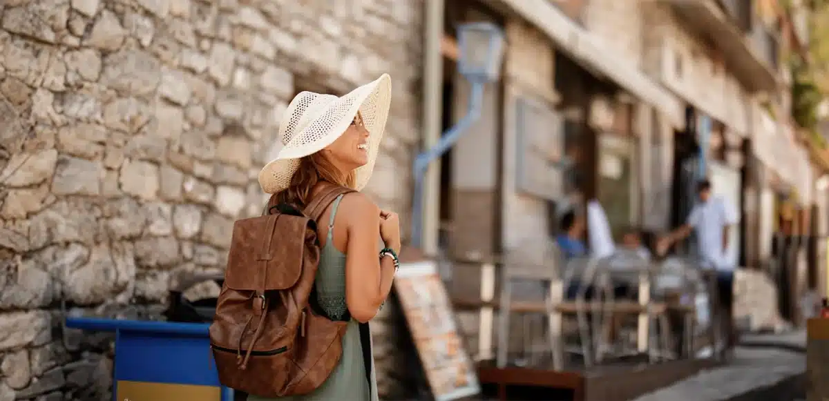 female tourist wandering around corfu hands-free after visiting a luggage storage in corfu